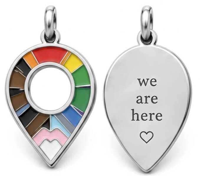 Two heart-shaped pendants, one with a rainbow design and the other with 'we are here' text.