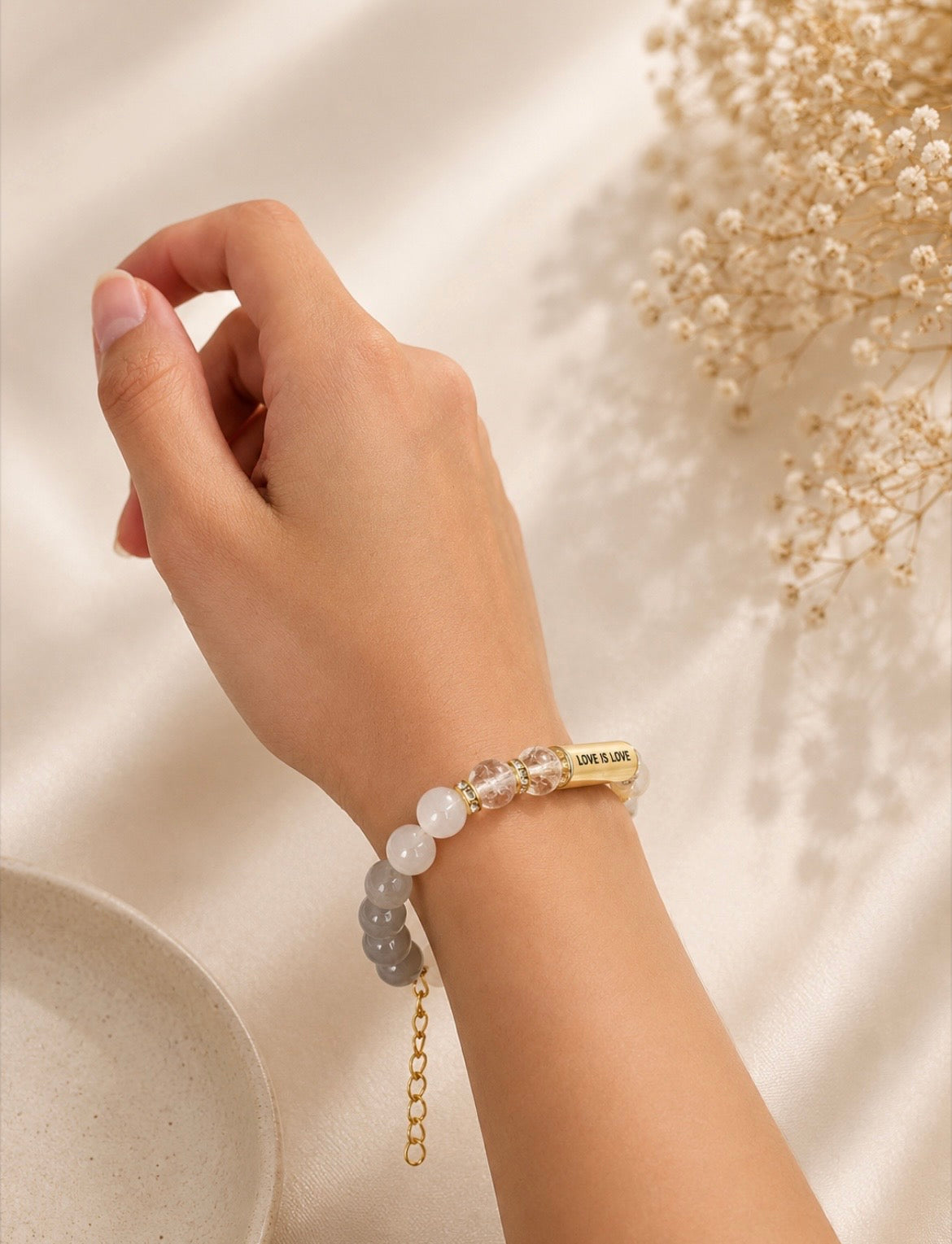 Love Is Love Bracelet worn on raised wrist — LGBTQ+ pride jewelry by LOUD SOULS