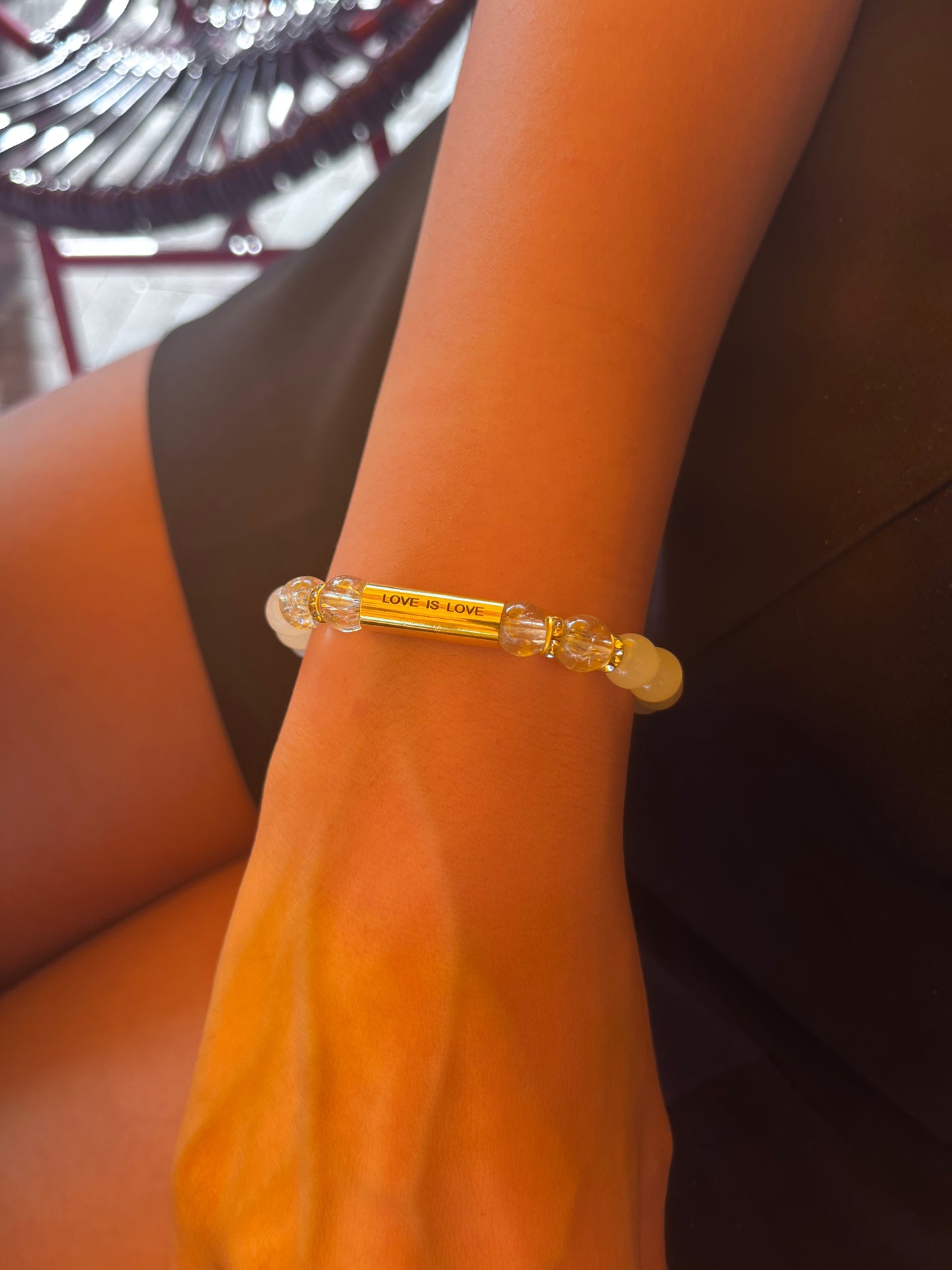 Love Is Love Bracelet worn outdoors against a brick wall — handcrafted pride bracelet