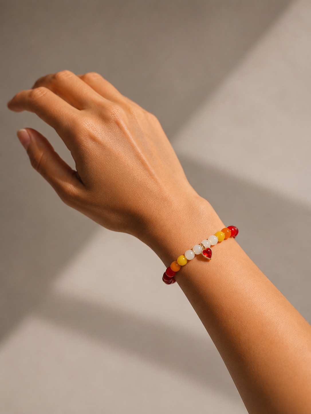 Sunset Heart Bracelet worn on wrist showing gradient sunset bead colors and heart charm detail