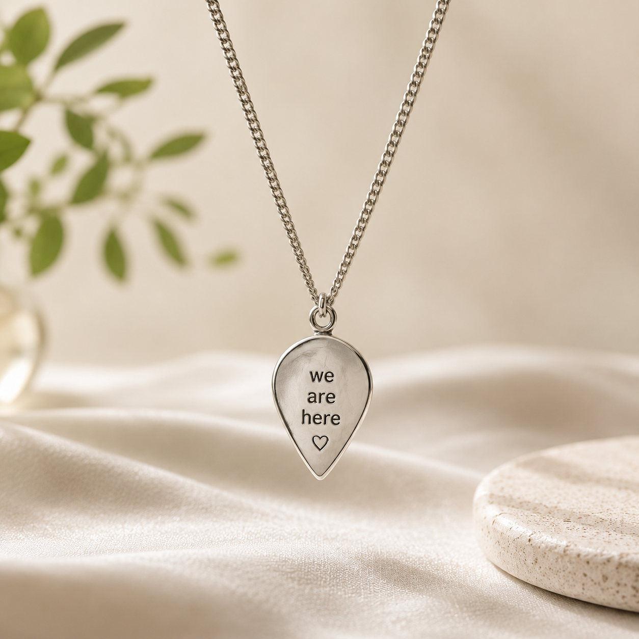 Close-up of We Are Here Location Pendant showing progress pride flag enamel design and silver pin shape